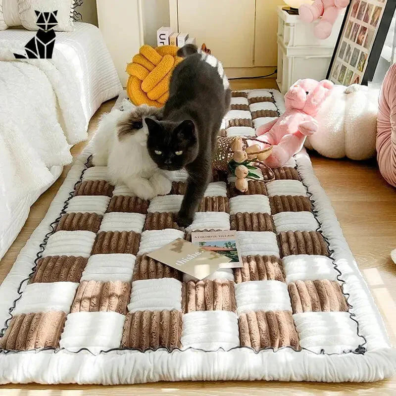 Chat jouant avec un animal en peluche sur un tapis devant une housse de canapé à carreaux crème protégeant le canapé